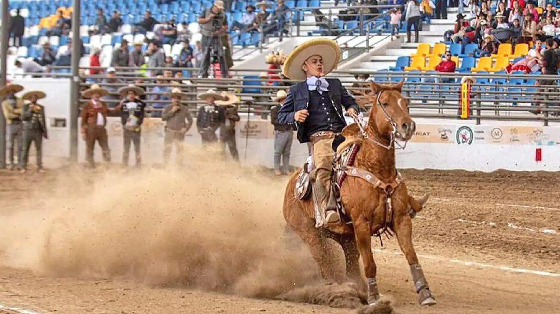 jinete charro en su caballo derrapando la arena